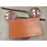 Two copper warming pans and a leather case