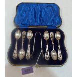 An Edward VII cased set of six silver teaspoons and sugar bow with foliate pierced terminals and