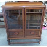 A 1930s oak and inlaid glazed bookcase
