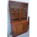 An oak bookcase, the upper part enclosed by a pair of glazed doors. 42' wide