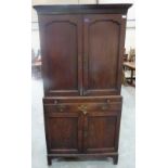 An 18th century oak estate cupboard, the upper part with a pair of panel doors enclosing a