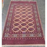 A Pakistani red and beige ground rug. 76' x 48'