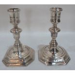 A pair of William III silver candlesticks, by Anthony Nelme with banded nozzles and knopped stems on