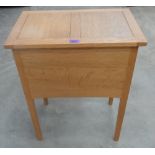 A light oak sewing box on square legs