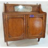 An Edwardian oak bathroom cabinet enclosed by a pair of doors. 17' wide