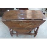 An oak gateleg table with frieze drawer on turned legs. 36' wide