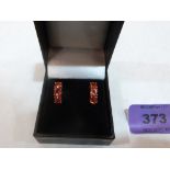 A pair of 9ct three stone orange tourmaline earrings. 2.1g gross