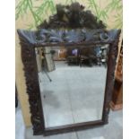 A wall mirror with acanthus carved and pierced wood frame and bevelled plate. 50½' high