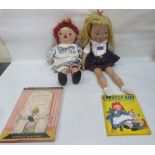 An American Eloise doll and a Raggedy Ann doll, each with accompanying story book