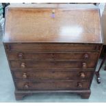 A George III oak bureau, the sloping fall over four long graduated drawers on bracket feet. 37'