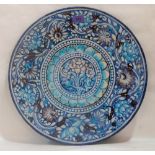 A Sind or Muttani style pottery charger, painted in shades of blue, turquoise and manganese with a