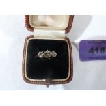 A three stone diamond ring. In gold marked 18ct. Size N. 2.2g gross