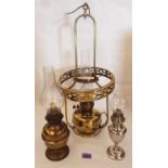 A brass hanging oil lamp converted for electricity; a Hugo Schneider oil lamp and one other