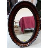 A 1930s oval wall mirror with bevelled plate. 34' high