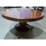 An early Victorian mahogany snap-top supper table on facetted bulbous column, the platform base on