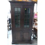 A 19th century joined oak and elm cupboard, enclosed by a pair of glazed doors over a pair of