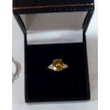 A green citrine and diamond ring. In gold marked 750. 2.7g gross. Size T