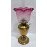 A Victorian brass oillamp with crimped ruby flashed shade and acid etched foliate decoration