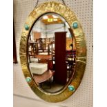 An Arts and Crafts brass wall mirror with bevelled plate, the frame with four inset turquoise '