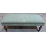 An upholstered footstool. 42' long