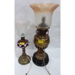 A late 19th century oillamp with ruby overlaid milchglass fount, together with a brass example, both