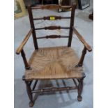 A 19th century ladderback country elbow chair with rush seat