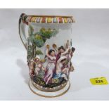 A Naples mug, typically decorated in high relief with a continuous scene of Bacchanalian revelry,