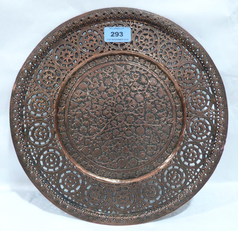 An oriental copper charger, pierced and chased with scrolling foliage. 12' diam