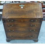 A George III fruitwood writing bureau, the sloping fall over four long graduated drawers, on bracket