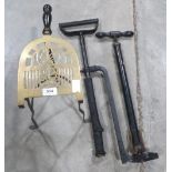 A 19th century brass and iron trivet and two stirrup pumps