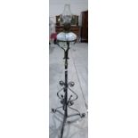 A wrought iron oillamp standard with marbled glass fount