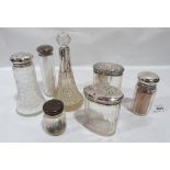 Four silver topped glass jars, a cut glass scent bottle, a cut glass sugar sifter and a silver