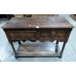 A Waring and Gillow oak dresser base with two short drawers, on spiral turned legs and undertier.