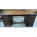 An early 20th century oak pedestal desk with leather inlet top and panelled sides. 66' wide