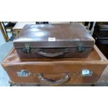 A vintage leather suitcase 24' wide and another smaller example