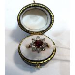 A garnet and white stone cluster ring. In gold marked 375. Size P. 3.4g gross