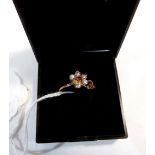 A gem set flower head ring. In gold marked 375. Size N. 1.9g gross