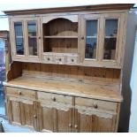 A pine dresser, the raised rack over three frieze drawers and conforming cupboards. 72' wide