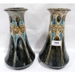 A pair of Arts and Crafts ceramic vases moulded with foliage on a mottled green glaze. 10' high. One