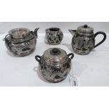 A Chinese bisque and white metal overlaid four piece tea service