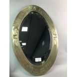 AN OVAL BEVELLED MIRROR