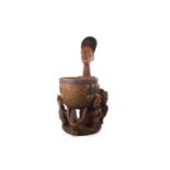 AN AFRICAN CARVED WOOD FIGURE WITH BOWL