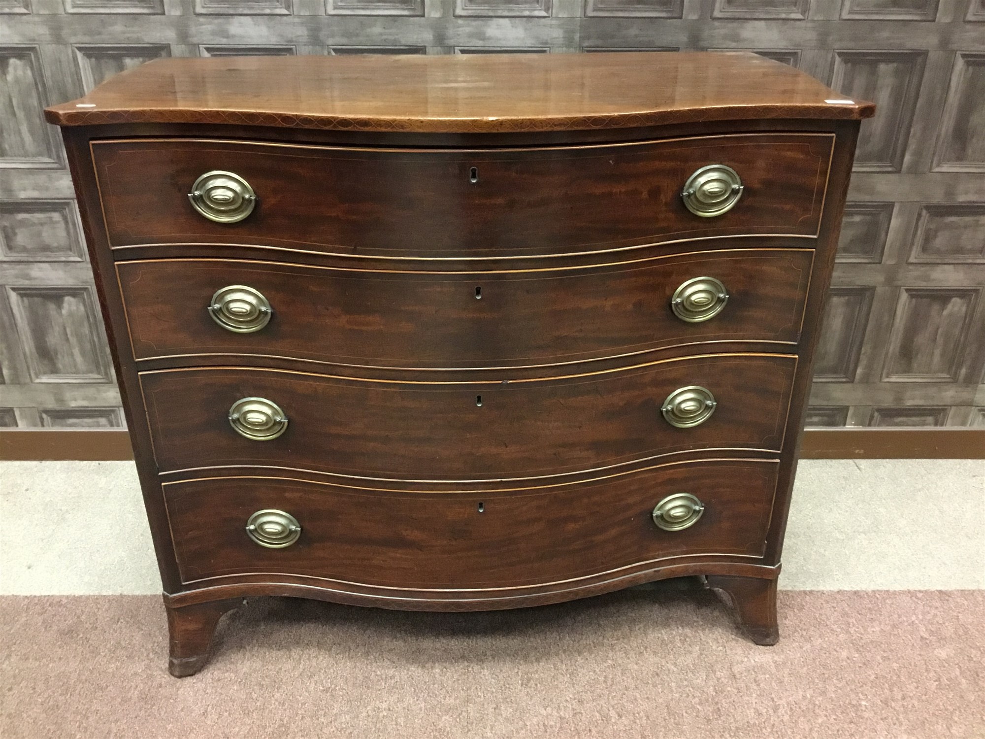 A MAHOGANY SERPENTINE COMMODE CHEST