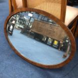 A MAHOGANY OVAL WALL MIRROR