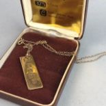 A GOLD INGOT PENDANT ON CHAIN