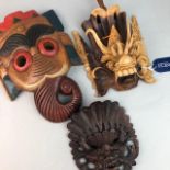 A LOT OF THREE EASTERN CARVED WOOD WALL MASKS