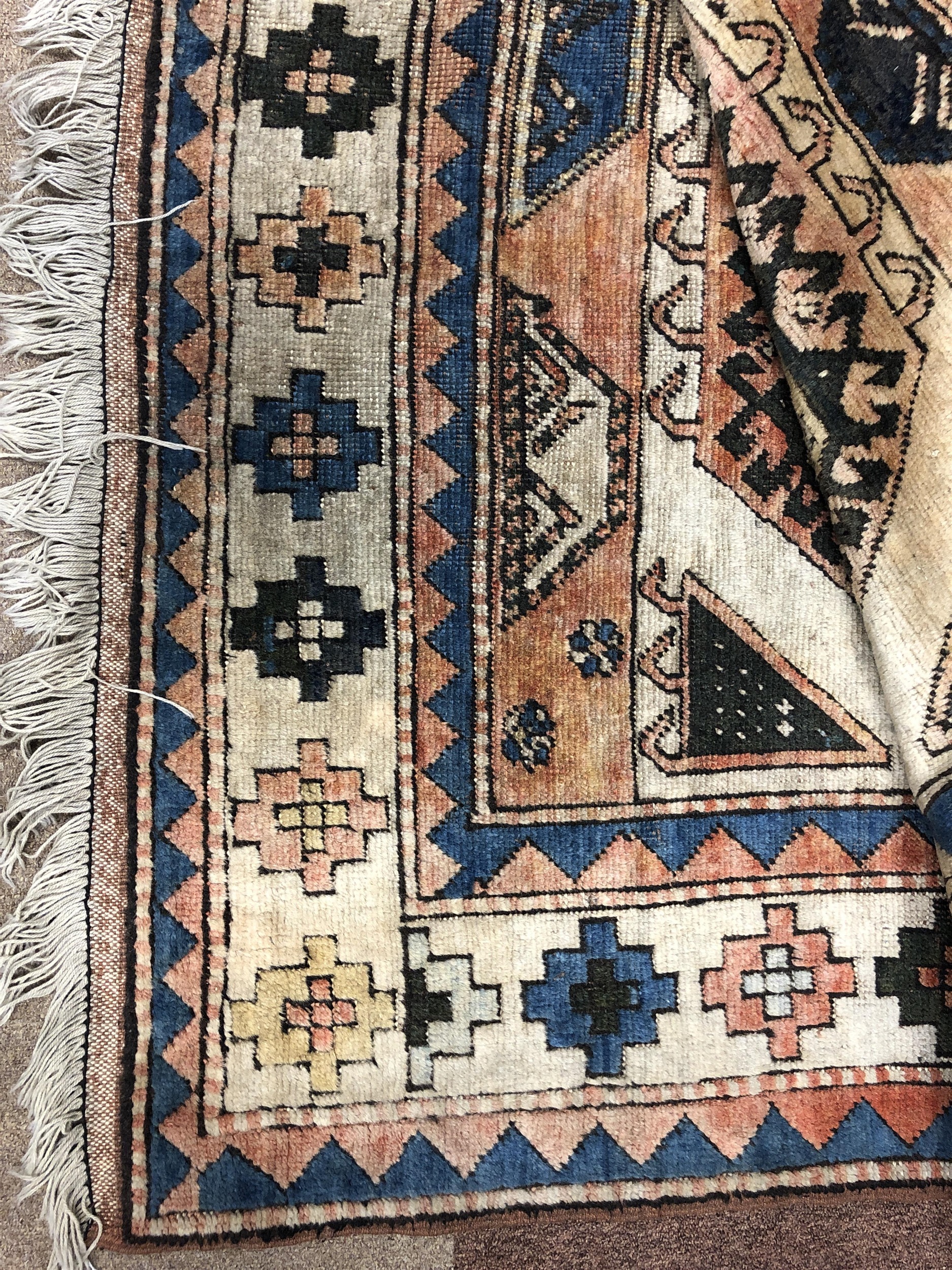 A MIDDLE EASTERN FRINGED CARPET