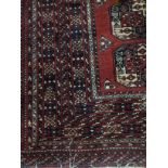 A 20TH CENTURY EASTERN FRINGED AND MULTI BORDERED CARPET