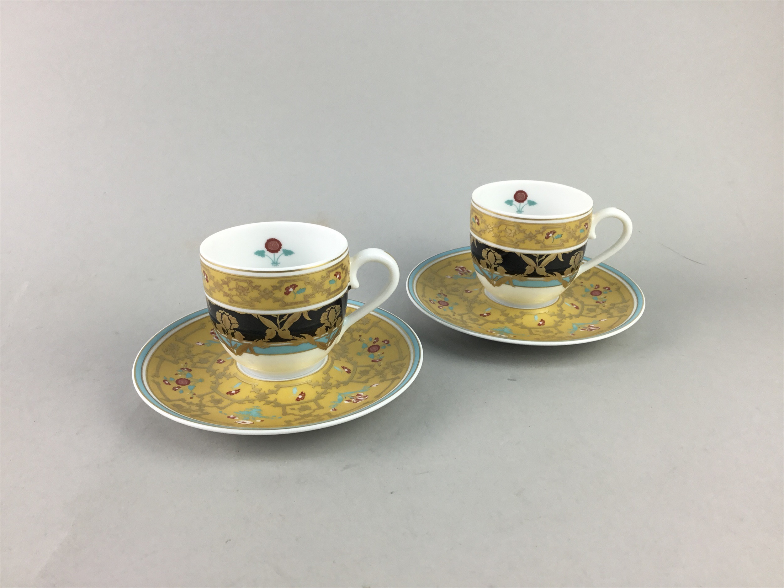 A PAIR OF LIMOGES CUPS AND SAUCERS RETAILED BY THOMAS GOODE