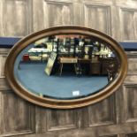 AN OVAL BEVELLED WALL MIRROR
